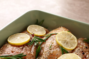 Chicken breasts with lemon and rosemary on grey table, closeup