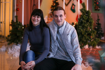 Obraz premium adult brother and sister in Christmas decorations smiling and hugging