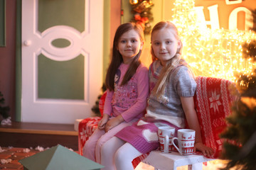 two girls in Christmas decorations smiling and hugging