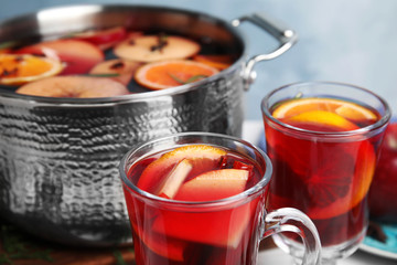 Tasty mulled wine with spices on table, closeup
