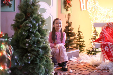 little girl sitting on the doorstep in New Year's decorations