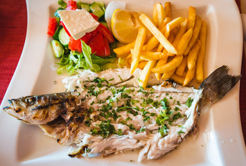 delicious fish cooked on the grill behind the plate