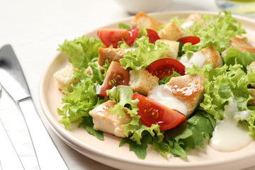Delicious fresh Caesar salad on plate, closeup