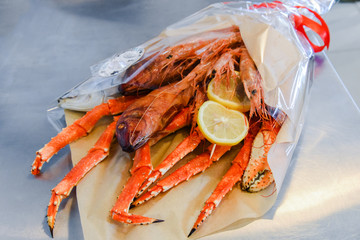 Bouquet consisting of a large crab, salted fish, large shrimp and lemon. Seafood is Packed in food paper and transparent film.