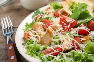 Delicious fresh Caesar salad on wooden table, closeup