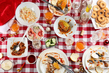 Flat lay composition of food leftovers after party on table with checkered cloth