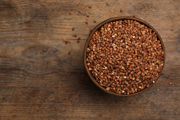 Buckwheat grains on wooden table, top view. Space for text