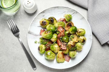 Delicious Brussels sprouts with bacon served on light table, flat lay