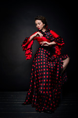 Carmen beautiful woman in red dress on dark background
