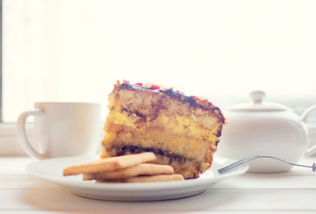 Slice of cake on white wooden background