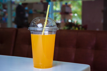Orange juice in box with drinking can on table