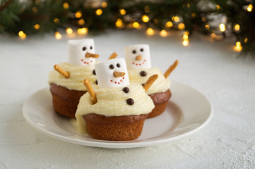 Christmas chocolate cupcakes with snowman decor. on dark background.