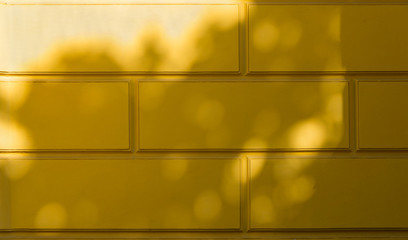 Yellow wall with shadows on it.