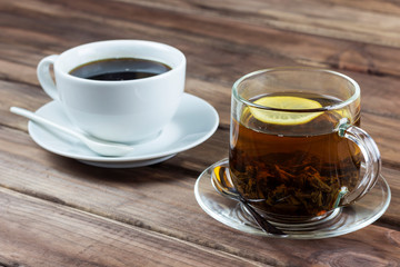 cup of tea with lemon and a cup of coffee on a wooden surface, the choice between coffee and tea	