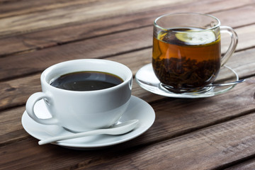 cup of tea with lemon and a cup of coffee on a wooden surface, the choice between coffee and tea	