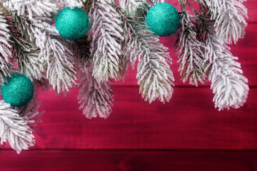 Blue Christmas balls on spruce frosty brunches over wooden background. Xmas and New Year background