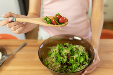 Young beautiful girl is preparing healthy organic food for breakfast.