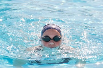 Face of young women swimmer in pool, girl in cap goggles for swimming