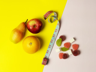 The concept of diet, proper nutrition. Colored backgrounds are from different sides of good and bad food. In the middle is a measuring tape