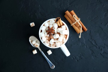 Mug of hot chocolate with marshmallows on a dark background. Top view, copy space.