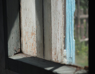 An old shabby village window and the morning light showing through it. The concept of antiquity and deveren