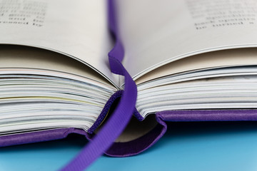 A hardback book with bookmark lying closed close up, selective focus