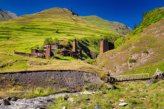 The ancient mountainous Georgian village of Omalo, Tusheti region, Georgia. Bright blue sky, stone houses and towers, green lush grass and a fast river.