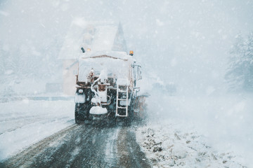 snowblower clears a snowy road, heavy snowfall, view from a car window. - 300729223