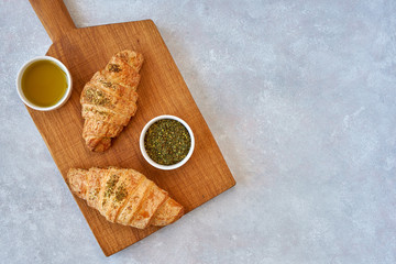 Fresh croissants with zaatar on wooden board