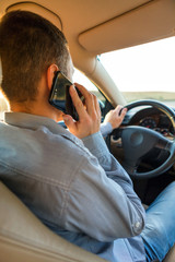 Hand using phone sending a text while driving to work ,businessman