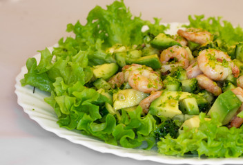fresh salad with avocado and shrimp on a plate macro