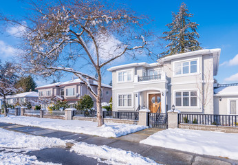 A perfect neighbourhood. Houses in suburb at Winter in the north America. Luxury houses covered...