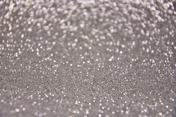 Blurred abstract background with sparkle shiny bokeh. Romantic holiday bokeh background with soft focus and magical shimmering. Christmas and new year card. Grey bokeh backdrop 