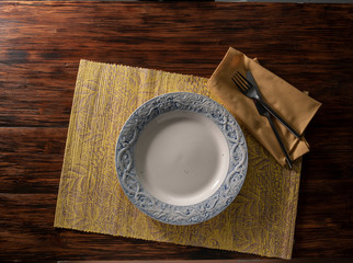 mesa y plato  con cenefa azul cenital con servilleta. table and plate with blue top border with...