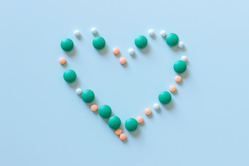 Round tablets are arranged in the shape of a heart. Concept of prevention and treatment.