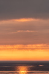 Naklejka na ściany i meble sunset on the sea. the sun behind the cloud