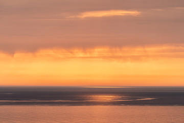 Naklejka na ściany i meble sunset on the sea. the sun behind the cloud