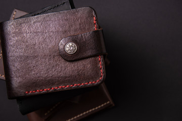 leather wallets on a black background with space for an inscription. Leather craft concept.