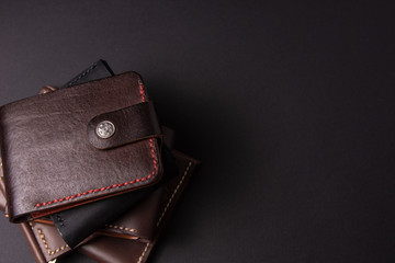 leather wallets on a black background with space for an inscription. Leather craft concept.