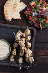 Grilled chicken skewers with hummus and salad