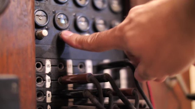 Close up on finger pressing buttons on vintage telephone exchange 