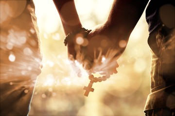 Couple praying together. Holding rosary in hand. © BillionPhotos.com