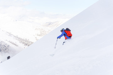 Fototapeta na wymiar Photo from back of sports man with backpack skiing