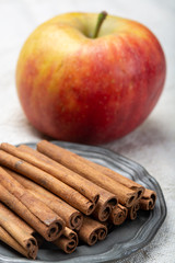 Winter pastry food ingredient, dried aromatic cinnamon sticks and apple on tin plate