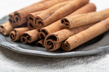 Winter food ingredient, dried aromatic cinnamon sticks on tin plate