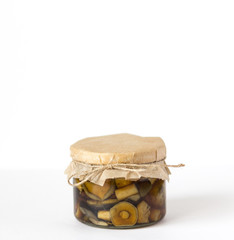Glass jar of pickled mushrooms on jute table clothpickled mushrooms in a glass jar on a white background with copy space