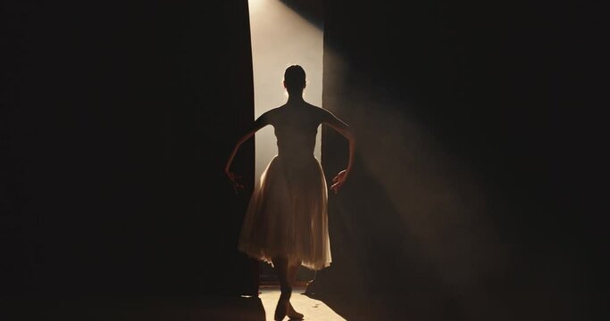Female ballet dancer performing on theatre stage, dancing while spotted by bright light, isolated on black background - arts concept 4k footage