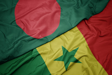 waving colorful flag of senegal and national flag of bangladesh.