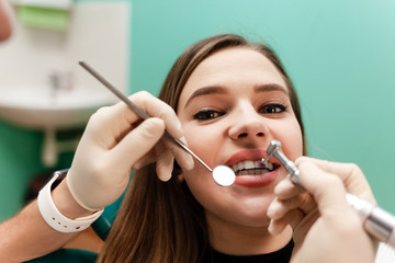 The doctor treats the patient's teeth with a drill close-up