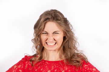 Angry woman in red dress portrait on a white background with grin teeth